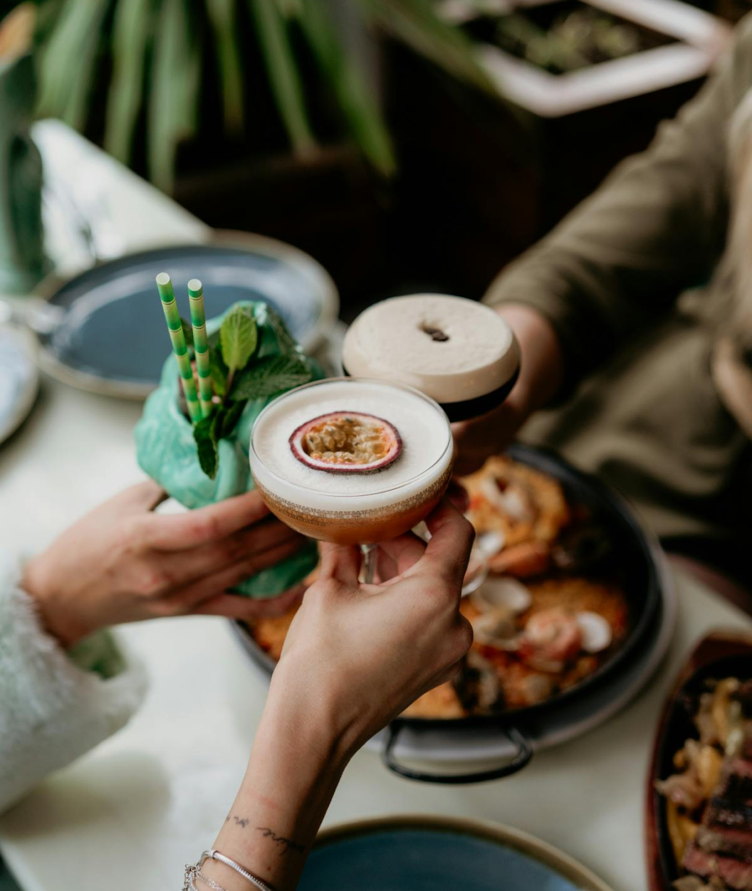 free-photo-of-people-clinking-glasses-over-the-table-with-food 1